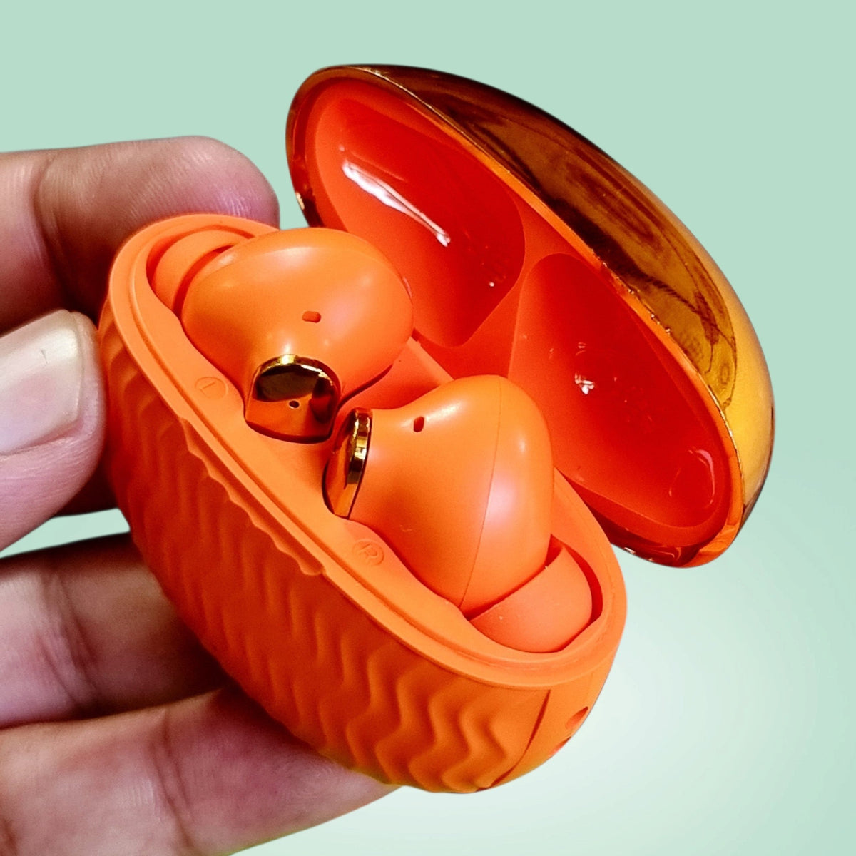 ADNAN MOBILE SHOP EarBuds 6 in bright orange with gold accents, held in a hand with an open charging case.